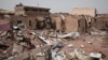 FILE - A man walks by a house hit in fighting in Khartoum, Sudan, an area torn by fighting between the military and the paramilitary Rapid Support Forces, April 25, 2023.