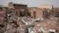 FILE - A man walks by a house hit in fighting in Khartoum, Sudan, an area torn by fighting between the military and the paramilitary Rapid Support Forces, April 25, 2023.