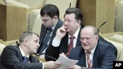 Communist Party leader Zyuganov talks with a deputy during a session of the lower house of parliament, the State Duma, in Moscow, 24 Dec 2010