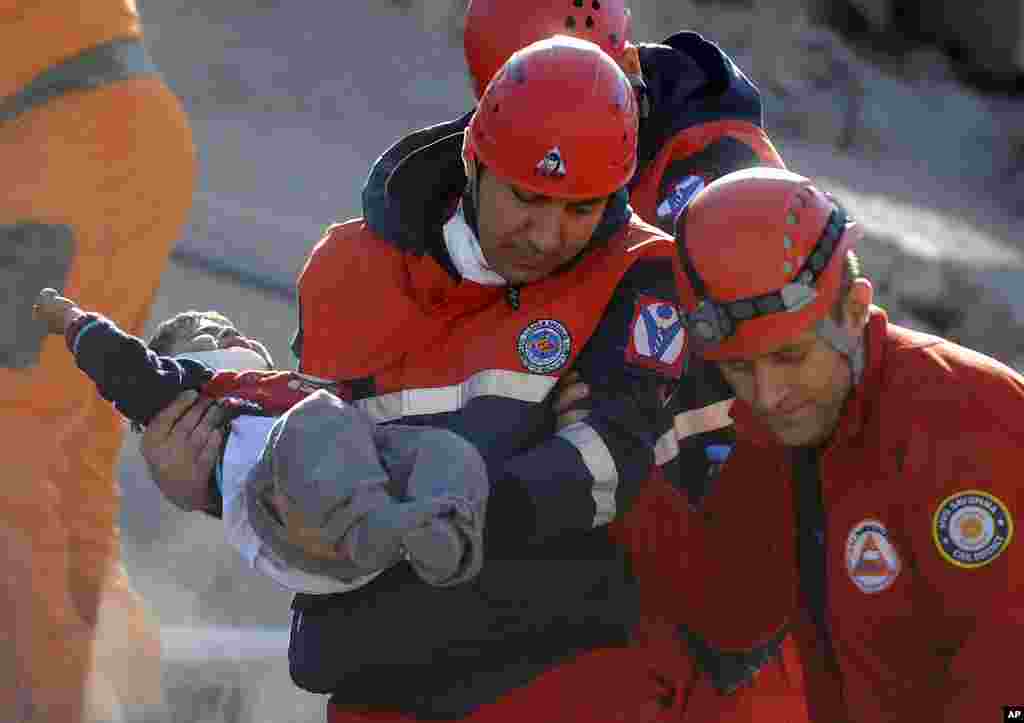 A rescue worker carries a boy to an ambulance after his team found him alive in a collapsed building in Ercis, near the eastern Turkish city of Van, October 24, 2011. (Reuters)