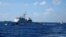 FILE - Chinese ships chase Vietnamese vessels, not shown, after they came within 10 nautical miles of a Chinese oil rig in the South China Sea, July 15, 2014. 