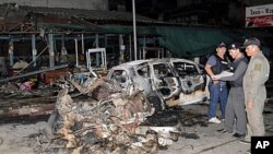 Thai security officers examine the site of a blast in Sungai Kolok, Narathiwat province, southern Thailand, September 16, 2011.