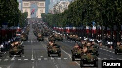 Armored army vehicles descend from the Champs Elysees during the traditional Bastille Day military parade in Paris, France, July 14, 2013.