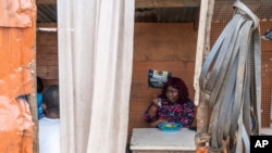 FILE - Anima Mangola eats rice and stewed cassava leaves in the Sierra Leone capital, Freetown, Sept. 25, 2024. 