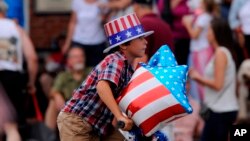 A youth on a bicycle joins the Water Street parade along the Apalachicola River during an Independence Day celebration in front of the city's fishing fleet, an ice cream social at Riverfront Park and a fireworks display, July 3, 2013, in Apalachicola, Fla