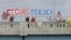 FILE - Demonstrators with signs on an overpass in Indianapolis, Indiana, protest against people who immigrate illegally.