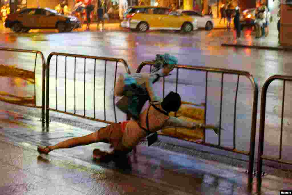 A woman falls as Typhoon Nesat hits Taipei, Taiwan, July 29, 2017.