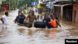 FILE - Rescuers evacuate people from a flooded area to a safer place in Aluva in the southern state of Kerala, India, Aug. 18, 2018. 