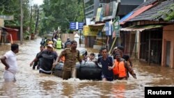 FILE - Rescuers evacuate people from a flooded area to a safer place in Aluva in the southern state of Kerala, India, Aug. 18, 2018. 