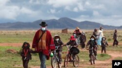 Indígenas aymaras transitan cerca de Jesús de Machaca, cerca de La Paz, usando mascarillas de protección contra el coronavirus, el 4 de efebrero de 2021.