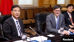 U.S. Secretary of Treasury Jacob Lew (C) and China's Vice Premier Wang Yang (L) sit before the start of a China Strategic and Economic Dialogue meeting at the U.S. Treasury Department in Washington, July 11, 2013. 