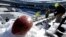 A football with the Super Bowl XLVIII logo is set on a mound of snow as workers shovel snow off the seating area at MetLife Stadium as crews removed snow ahead of Super Bowl XLVIII following a snow storm, Jan. 22, 2014, in East Rutherford, New Jersey.