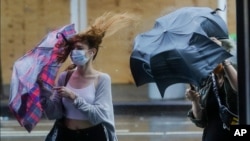 Pedestrians struggle to control their umbrellas in inclement weather brought about by Tropical Storm Fay on July 10, 2020, in New York. 