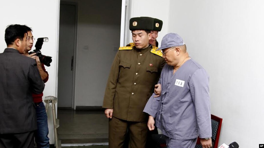 American missionary Kenneth Bae, right, leaves after speaking to reporters at Pyongyang Friendship Hospital in Pyongyang Monday, Jan. 20, 2014. 