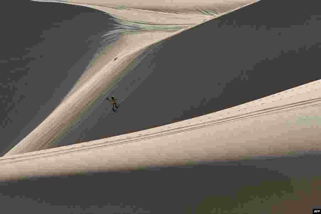 Nguyen Thai Binh surfs down sand dunes on his snowboard in the southern Vietnamese town of Mui Ne.