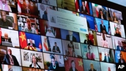 World leaders are shown on a screen as President Joe Biden speaks to the virtual Leaders Summit on Climate, from the East Room of the White House, April 23, 2021, in Washington.