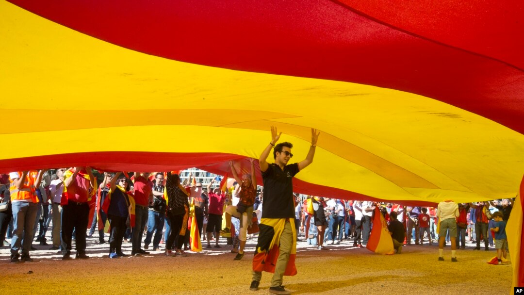 Seorang remaja berjalan di bawah bendera Spanyol raksasa di Madrid, Spanyol, Sabtu, 7 Oktober 2017.