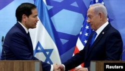 Menteri Luar Negeri AS Marco Rubio berjabat tangan dengan PM Israel Benjamin Netanyahu usai konferensi pers bersama di Yerusalem pada hari Minggu (16/2). 