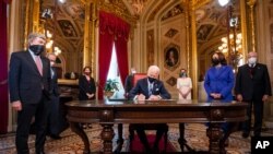 El presidente Joe Biden firma tres documentos que incluyen una declaración de investidura, nominaciones al gabinete y nominaciones al subgabinete después de la ceremonia de inauguración, el miércoles 20 de enero de 2021. [Foto: Vía AP]