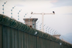 FILE - Security cameras are seen above the perimeter fence of what is officially known as a vocational skills education center in Dabancheng, in Xinjiang Uighur Autonomous Region, China, Sept. 4, 2018. Critics call these centers "re-education camps.