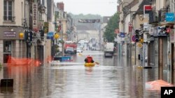 Residents use a canoe to evacuate in downtown Nemours, 50 miles south of Paris, June 2, 2016. 