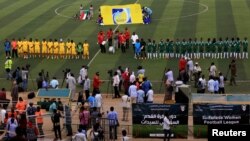 Les joueuses des équipes Al-tahadi (en vert) et Al-Difaa (en jaune) avant le premier match de football féminin du Soudan au stade de Khartoum, le 30 septembre 2019.