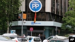 A TV crew works outside the Popular Party headquarters in Madrid, May 24, 2018. Spain's National Court has issued hefty prison sentences for politicians and business people involved in a kickbacks-for-contracts scheme that helped fund the ruling governing Popular Party.