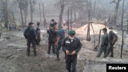 Petugas keamanan Thailand memeriksa lokasi kebakaran di kamp pengungsi Ban Mae Surin dekat Mae Hong Son, 800 kilometer sebelah utara Bangkok (23/3).