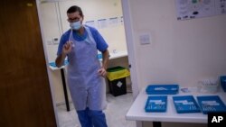 A health worker holds a Pfizer-BioNTech COVID-19 vaccine at the vaccination centre in Gibraltar, March 4, 2021. 