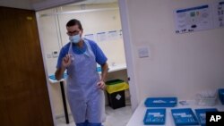 A health worker holds a Pfizer-BioNTech COVID-19 vaccine at the vaccination centre in Gibraltar, March 4, 2021. 