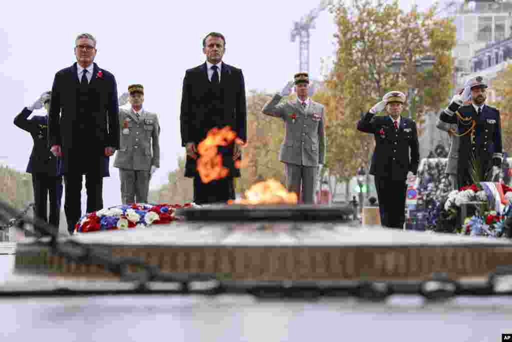 French President Emmanuel Macron, center, and Britain&#39;s Prime Minister Keir Starmer stand at attention at the Tomb of the Unknown Soldier during commemorations marking the 106th anniversary of the November 11, 1918, Armistice, ending World War I,&nbsp; in Paris.