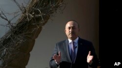Turkish Foreign Minister Mevlut Cavusoglu speaks to the media during a press conference with Turkish Cypriot leader Mustafa Akinci in Nicosia, Cyprus, Feb. 21, 2017. Cavusoglu says recent Greek Cypriot actions show that rights for Turkey to militarily int