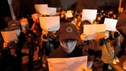 Demonstran mengangkat kertas kosong sebagai protes, Beijing, 27 November 2022. Pemerintah selalu mengawasi dan melakukan penyensoran dengan ketat, sehinggga kertas putih adalah simbol protes diam-diam masyarakat yang tidak diizinkan berbicara. (Foto: AP/Ng Han Guan)