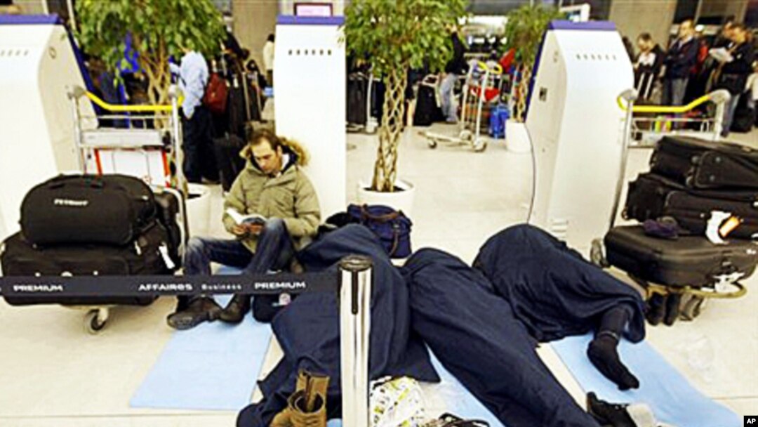 Passengers wait for their flights in a terminal after sleeping a night at the Charles-de-Gaulle Roissy airport, Paris, 24 Dec 2010