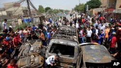 Warga berkumpul di lokasi ledakan bom mobil di distrik Sadr City, Baghdad, Kamis (16/5). 