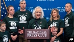 Surrounded by her children and their families, Debra Tice, mother of Austin Tice, a journalist who was kidnapped in Syria, speaks during a news conference at the National Press Club in Washington, Dec. 6, 2024. Debra Tice said she has evidence her son is detained in Damascus.