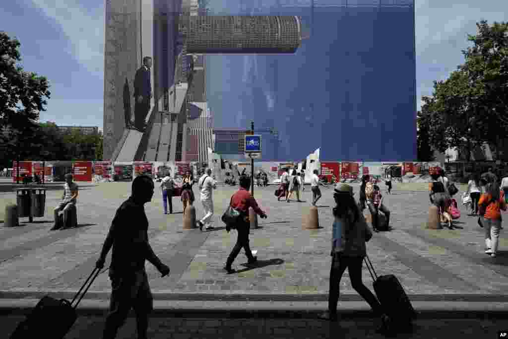 Des gens marchent en face d'une station de taxis pendant que des chauffeurs de taxi manifestent contre le groupe américain Uber à Lyon, centre de la France, le 25 juin, 2015.
