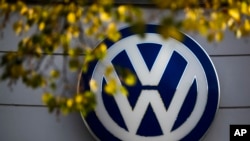 FILE - The VW sign of Germany's car company Volkswagen is displayed at the building of a company's retailer in, Berlin, Germany. 