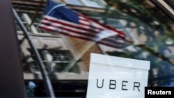 FILE - An Uber sign is seen in a car in New York, June 30, 2015. 