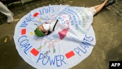 An environmental activist takes part in a protest in Jakarta on November 5, 2021, calling on world leaders attending the COP26 climate change conference in Scotland to reduce emissions and obtain zero deforestation in development. 