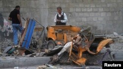 Members of a bomb disposal squad survey the site of a bomb blast outside a mosque in Karachi, Pakistan, June 5, 2014.