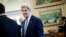 Secretary of State John Kerry is seen in the Oval Office of the White House in Washington, Monday, March 17, 2014, during President Barack Obama's meeting with Palestinian President Mahmoud Abbas.