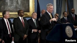 New York City Mayor Bill de Blasio, accompanied by local, state and federal law enforcement officials at Manhattan's City Hall, speaks to reporters about the establishment of special courts and a police unit dedicated to gun-related cases, Jan. 12, 2016.