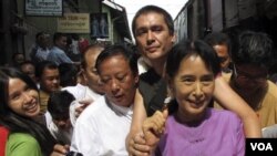 Aung San Suu Kyi bersama puteranya, Kim Aris (di belakang Suu Kyi) dan para pendukungnya di Yangon, Birma, 30 November 2010.