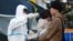 A man and a child are checked for radiation exposure in Fukushima in wake of the reactor meltdowns, March 13, 2011. (S. Herman/VOA)