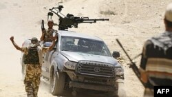 Ливийские повстанцы на захваченном у войск Каддафи внедорожнике в 100 км южнее Триполи. 30 июня 2011г.