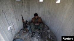 A Turkish-backed Free Syrian Army fighter rests at mount Bafliyun, in the Afrin region, Syria.