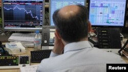 A trader looks at his screens during a bond auction on a trading floor in Madrid, June 7, 2012. 