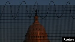 FILE - The U.S. Capitol Building can be seen behind fencing with barbed wire in Washington, Jan. 28, 2021. A small group of white nationalists marched to the Capitol on Jan. 29, 2021.