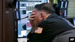 A trader works in his booth on the floor of the New York Stock Exchange, in New York, Oct. 26, 2018. 